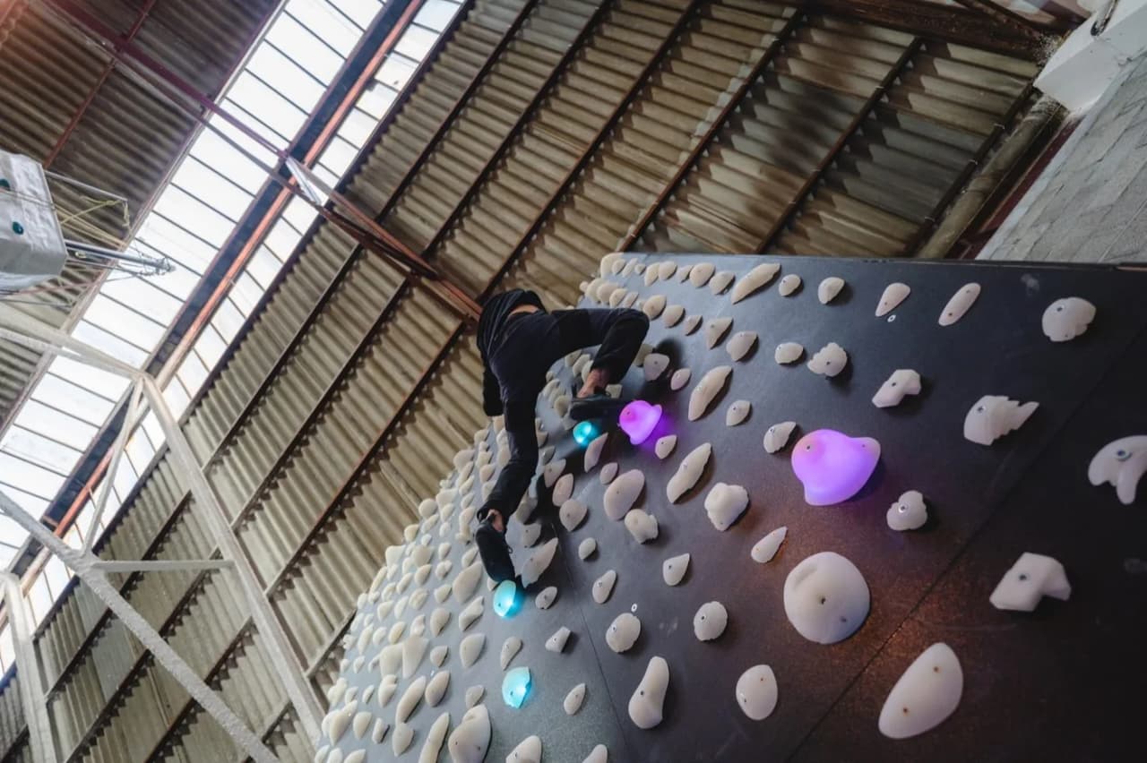 Escalador en una pared de boulder a medida de Shiny Wall en el CEM de Cerdanyola