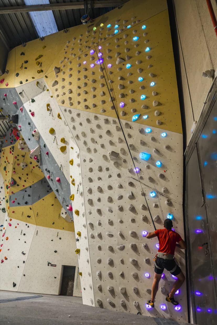 Escalador en una pared de escalada con cuerda a medida de Shiny Wall en Indoorwall Vic